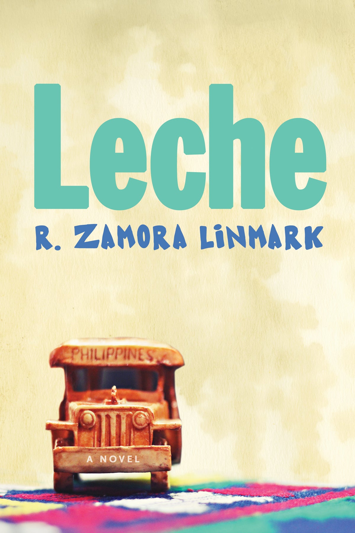 Cover of "Leche," by R. Zamora Linmark, which shows a little toy vehicle etched with 'Philippines' on it, and the toy is positioned on a colorful rug. 